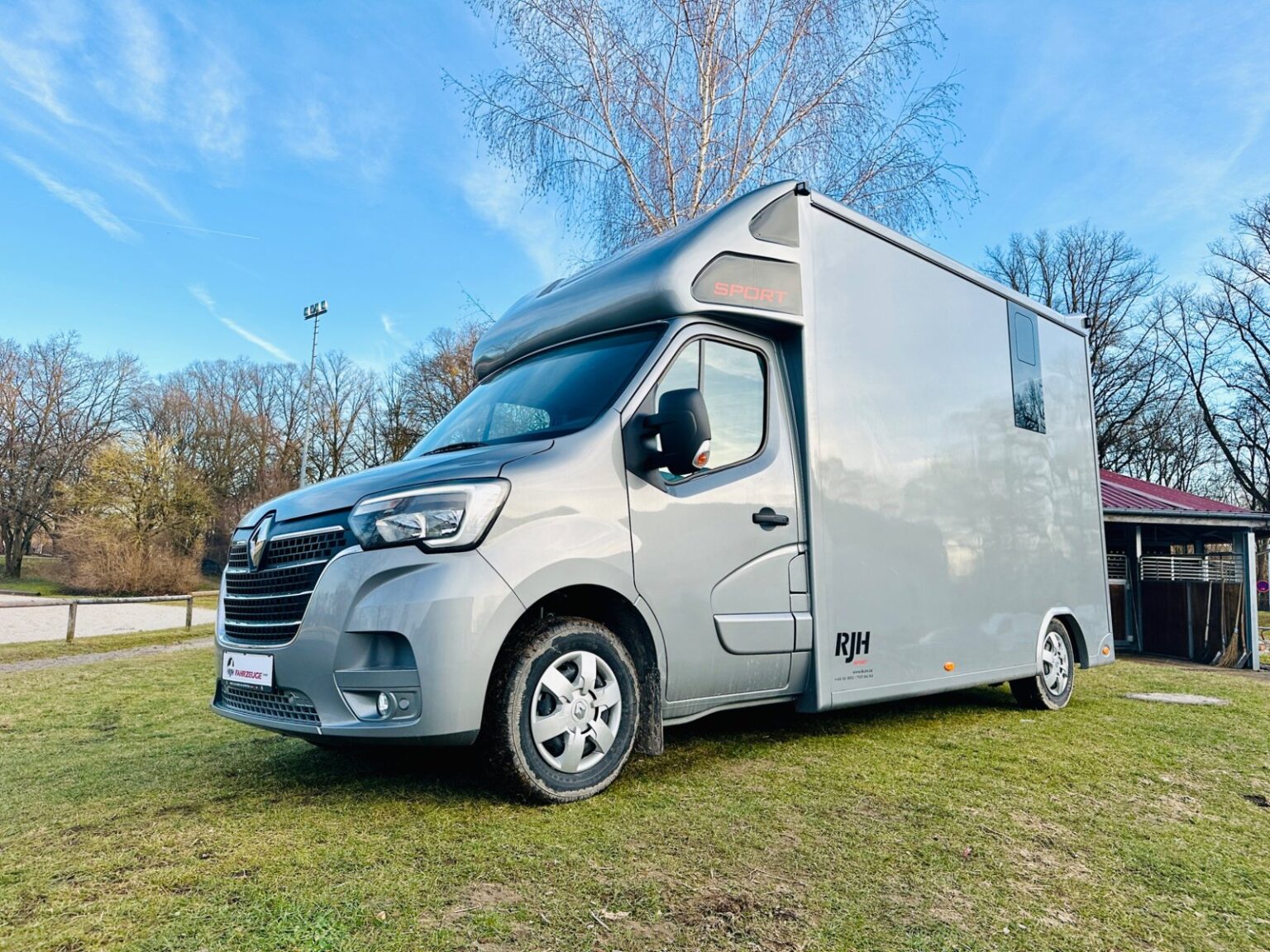 Praktischer Renault 2-Pferdetransporter steht auf einer Wiese unter blauem Himmel